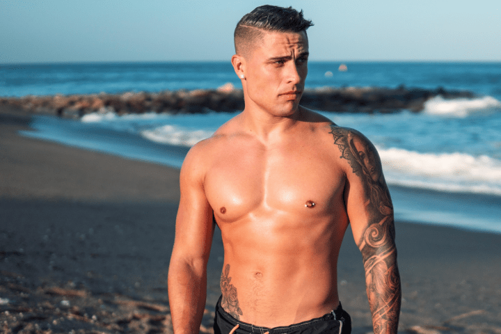 a man standing on a beach in front of a body of water